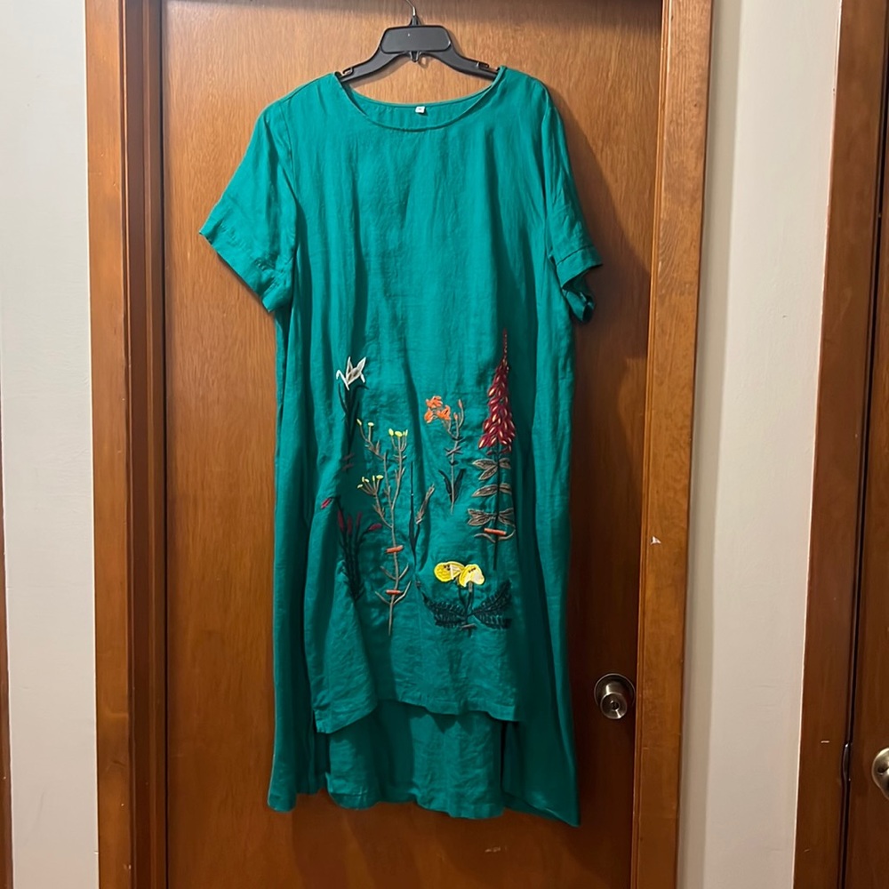 Green cotton/linen blend maxi dress higher in front with embroidered flowers.